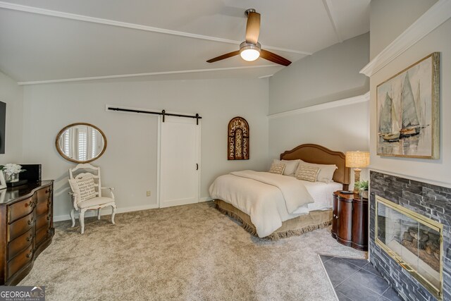 carpeted bedroom featuring ceiling fan, a barn door, a fireplace, and vaulted ceiling