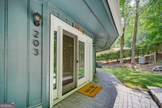 doorway to property with cooling unit and covered porch