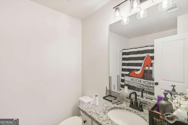 bathroom featuring vanity, a shower with shower curtain, and toilet