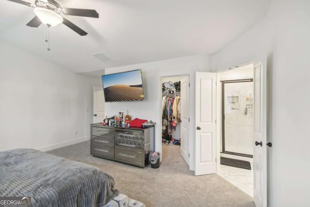 carpeted bedroom with a spacious closet, ceiling fan, and a closet