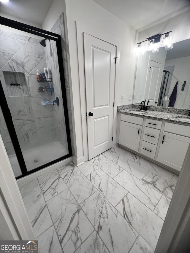 bathroom featuring a shower with door and vanity