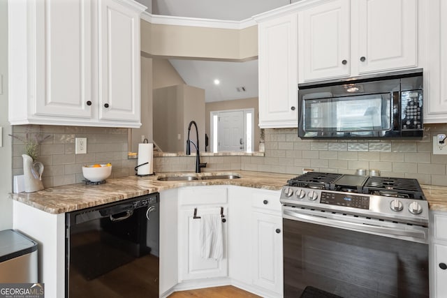 kitchen with black appliances, light stone counters, a sink, and white cabinetry