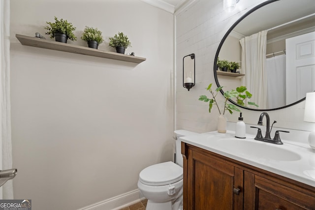 full bath with toilet, vanity, and baseboards