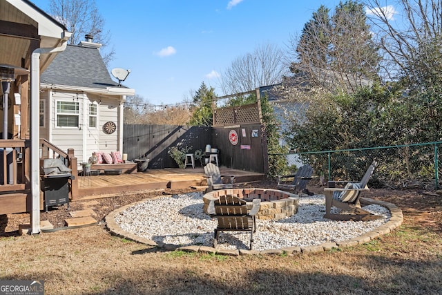 view of yard featuring a fire pit, a fenced backyard, and a wooden deck