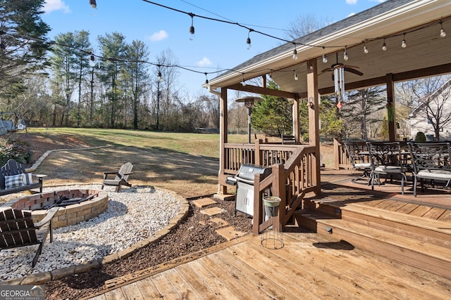 exterior space with an outdoor fire pit, a grill, a deck, and outdoor dining space