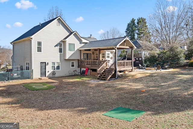 rear view of house with a shingled roof, a chimney, stairway, fence, and a deck