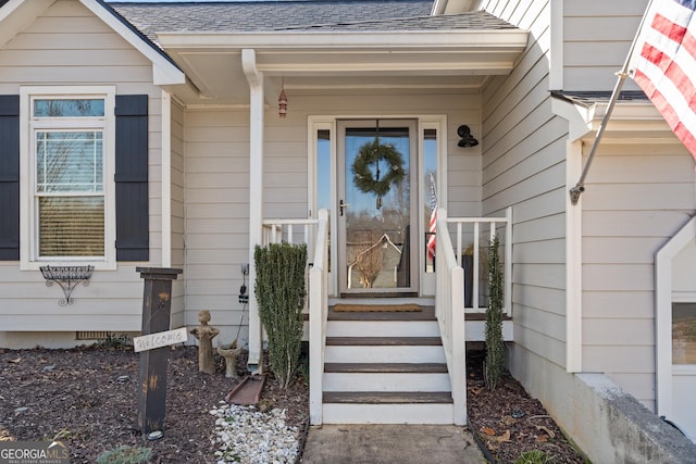 view of exterior entry with roof with shingles and crawl space