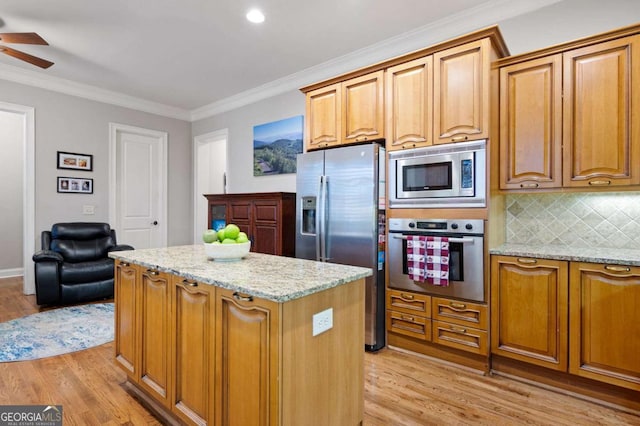 kitchen with stainless steel appliances, a center island, tasteful backsplash, light stone counters, and ornamental molding