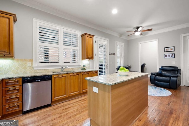 kitchen featuring sink, backsplash, a center island, light stone countertops, and stainless steel dishwasher