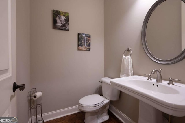 bathroom featuring wood-type flooring, toilet, and sink