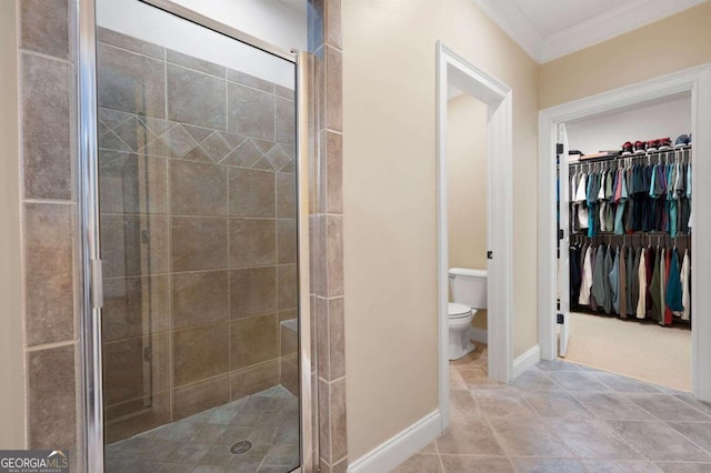 bathroom featuring crown molding, toilet, and a shower with door