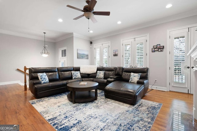 living room with crown molding, light hardwood / wood-style flooring, and ceiling fan