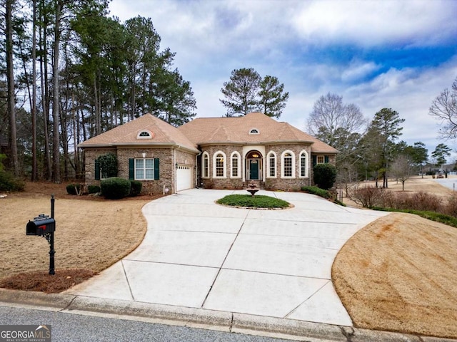 1010 Lane Creek Ct, Bishop, GA 30621 - view of front of house featuring driveway, a garage, and brick siding