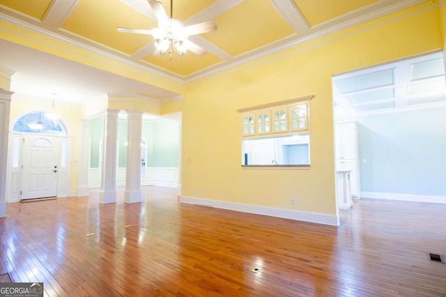 unfurnished living room with ceiling fan, decorative columns, crown molding, and coffered ceiling