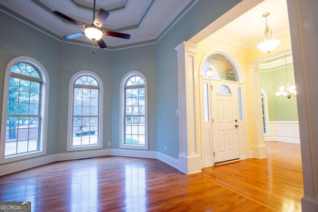 foyer featuring hardwood / wood-style flooring, ceiling fan with notable chandelier, and ornamental molding