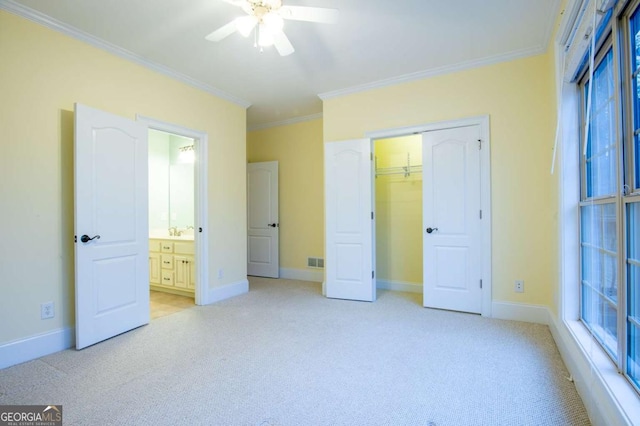 unfurnished bedroom with ornamental molding, light colored carpet, ceiling fan, sink, and a closet