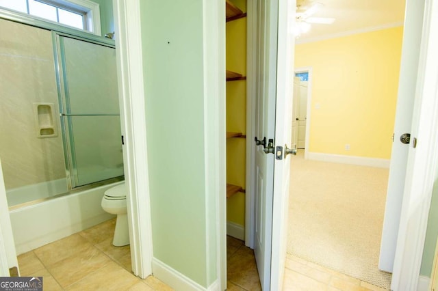 bathroom with shower / bath combination with glass door, crown molding, ceiling fan, and toilet