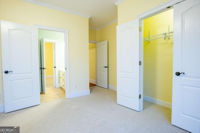 unfurnished bedroom featuring a walk in closet, ornamental molding, light carpet, and a closet