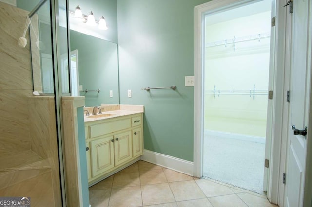 bathroom with tile patterned flooring, vanity, and a shower with door