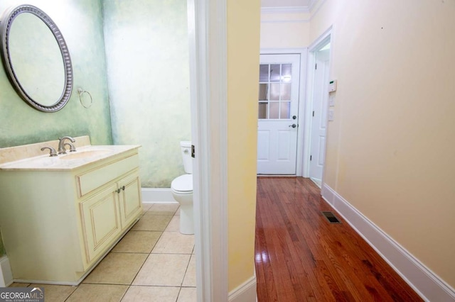 bathroom with tile patterned floors, vanity, toilet, and ornamental molding