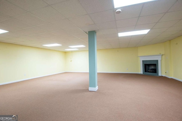 basement featuring carpet floors and a paneled ceiling