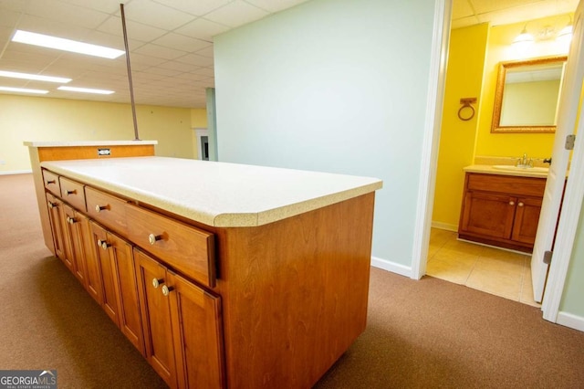 kitchen with a center island, light colored carpet, and sink