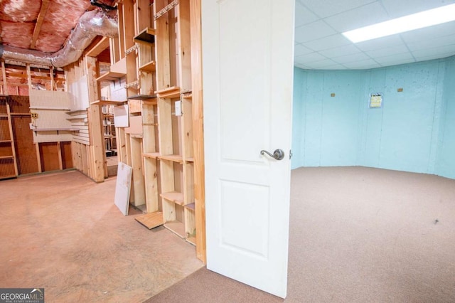 basement featuring carpet floors and a drop ceiling