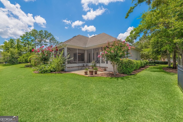 rear view of property featuring a lawn and a sunroom