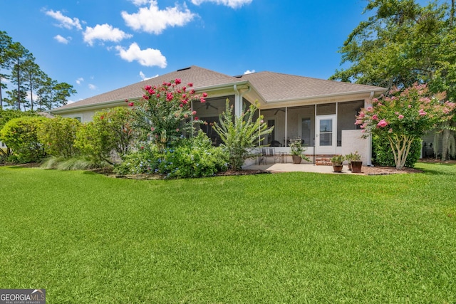 view of front of home featuring a sunroom, ceiling fan, and a front lawn