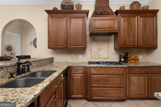 kitchen featuring sink, decorative backsplash, light tile patterned floors, light stone counters, and stainless steel gas cooktop