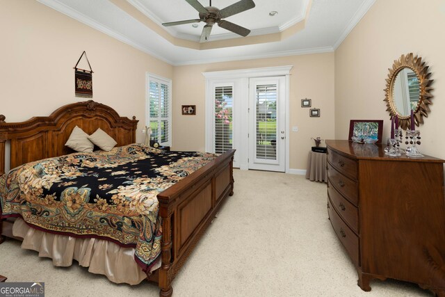 carpeted bedroom featuring access to outside, ceiling fan, crown molding, and a tray ceiling