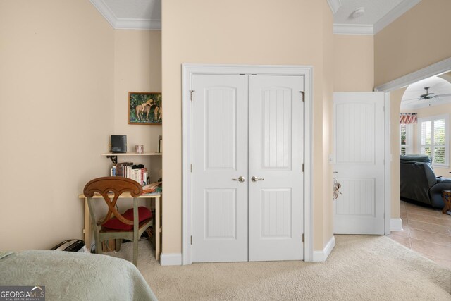 bedroom featuring light carpet, a closet, and ornamental molding