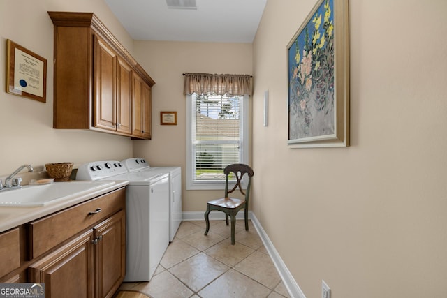 laundry room featuring cabinets, light tile patterned floors, washer and dryer, and sink