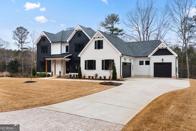 modern farmhouse style home with a front yard and a garage