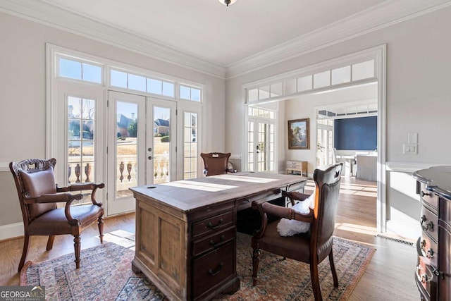 home office featuring french doors, light wood-type flooring, and ornamental molding