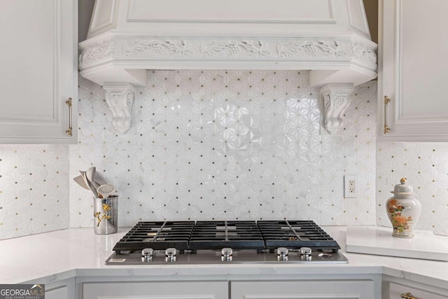 kitchen with white cabinets, stainless steel gas cooktop, and tasteful backsplash