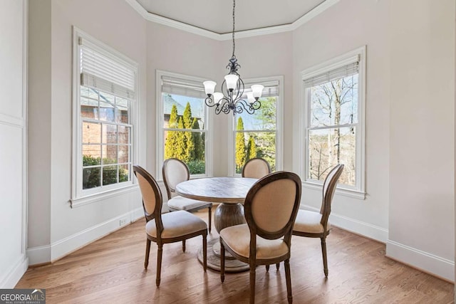 dining area featuring hardwood / wood-style flooring, crown molding, and an inviting chandelier