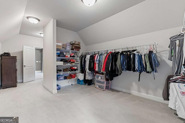 walk in closet featuring light carpet and vaulted ceiling