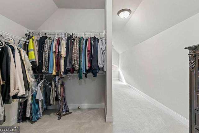 walk in closet featuring light colored carpet and vaulted ceiling