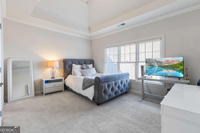 carpeted bedroom with ornamental molding, a high ceiling, and a tray ceiling