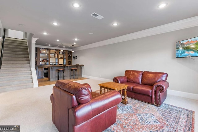 carpeted living room with crown molding and bar area