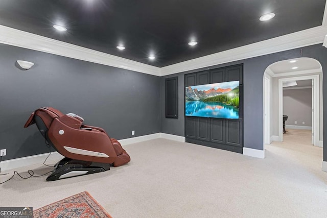 carpeted home theater featuring crown molding