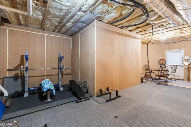 workout area featuring carpet and wood walls