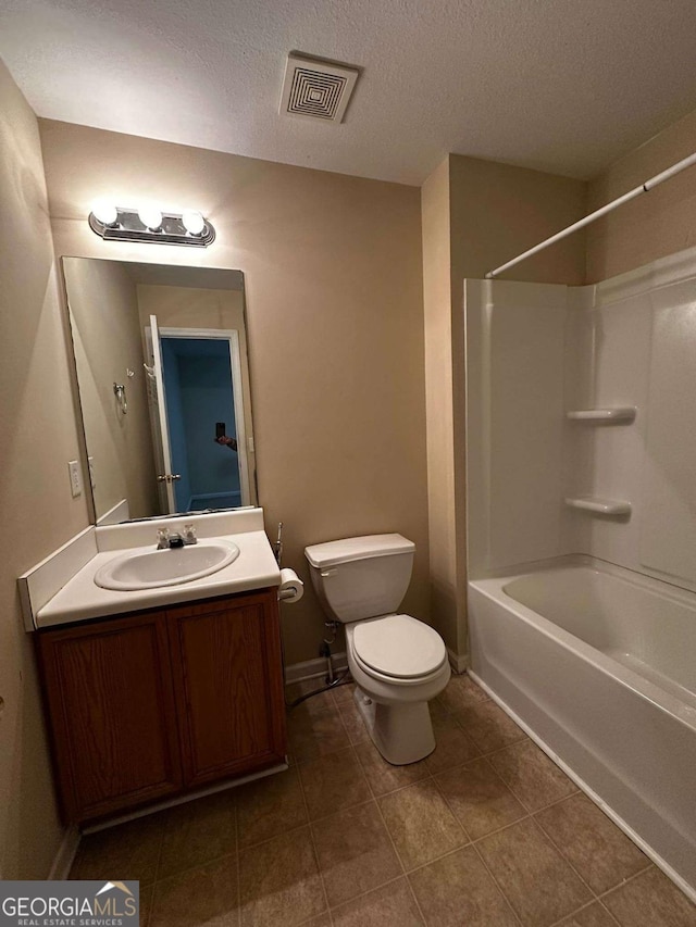 full bathroom with vanity, shower / tub combination, tile patterned floors, toilet, and a textured ceiling