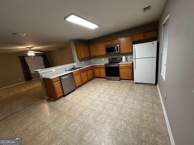 kitchen featuring kitchen peninsula, stainless steel appliances, ceiling fan, and sink