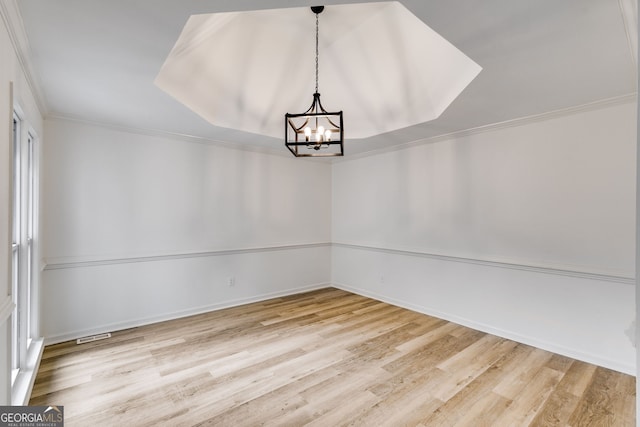 unfurnished dining area featuring a chandelier, hardwood / wood-style floors, and crown molding