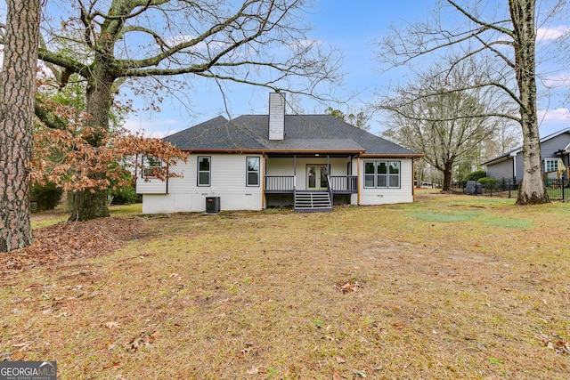 rear view of house featuring central AC, a yard, and a porch