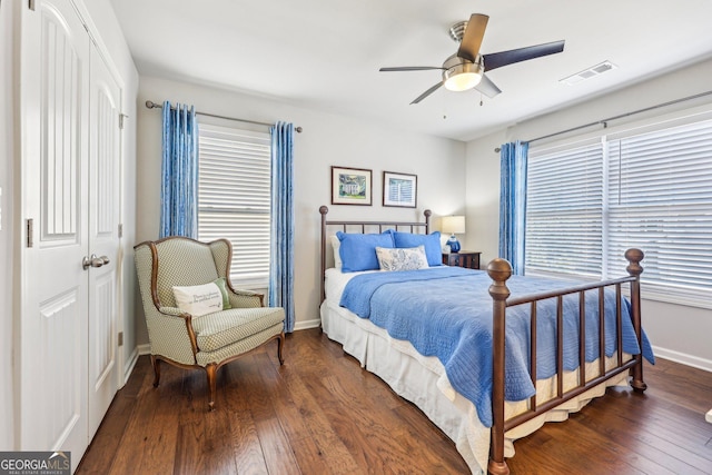 bedroom with ceiling fan, dark wood-type flooring, and a closet