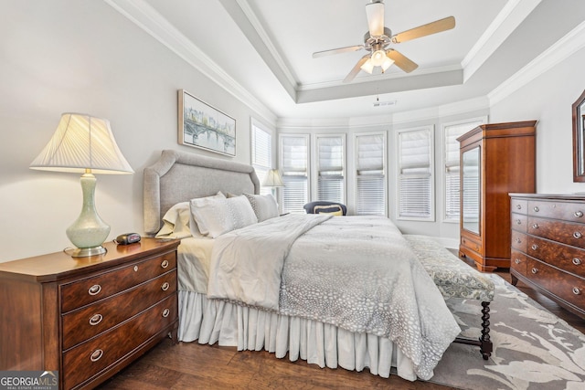 bedroom with ceiling fan, dark hardwood / wood-style floors, a raised ceiling, and crown molding