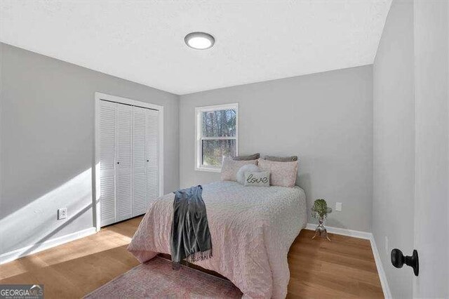 bedroom with a closet and light hardwood / wood-style floors